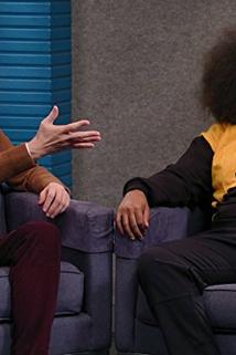 Profilový obrázek - Reggie Watts Wears a Purple and Yellow Quilted Sweatshirt